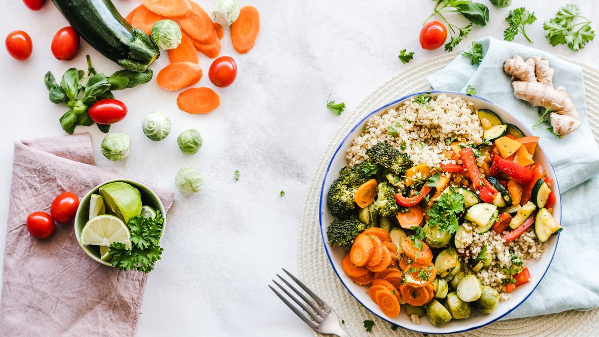 Five meal prep containers with grain bowls and colorful toppings