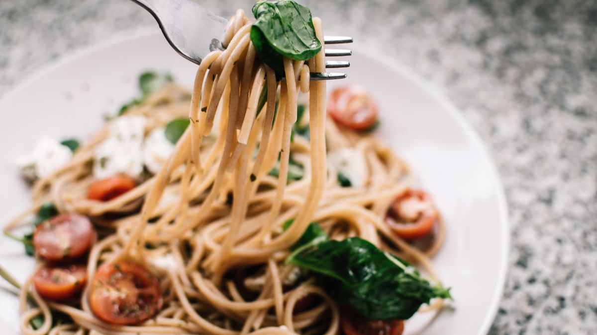 Creamy tomato pasta in a deep pot with basil